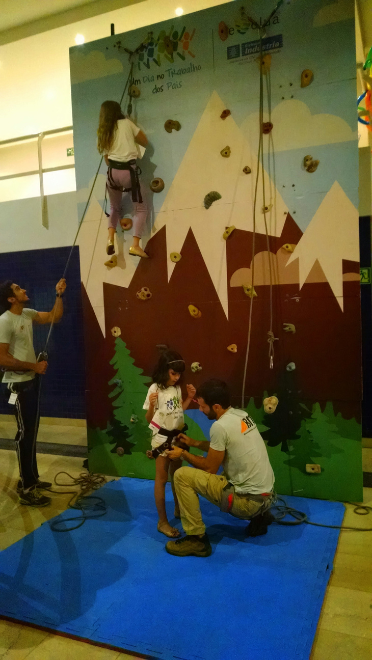 Crianças em atividade de escalada com equipe técnica