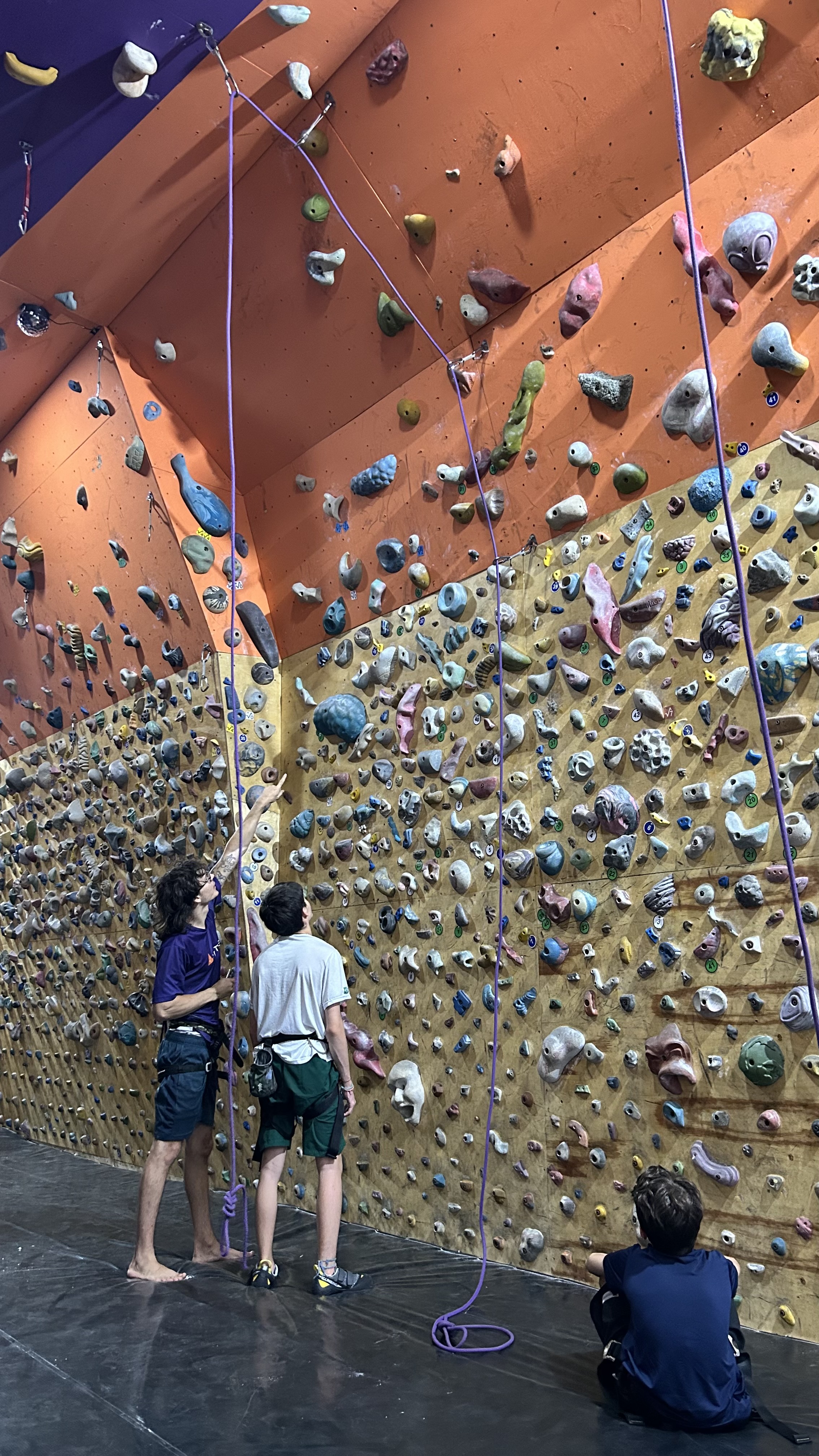 Alunos Teens recebendo orientação na parede de escalada da Vértice